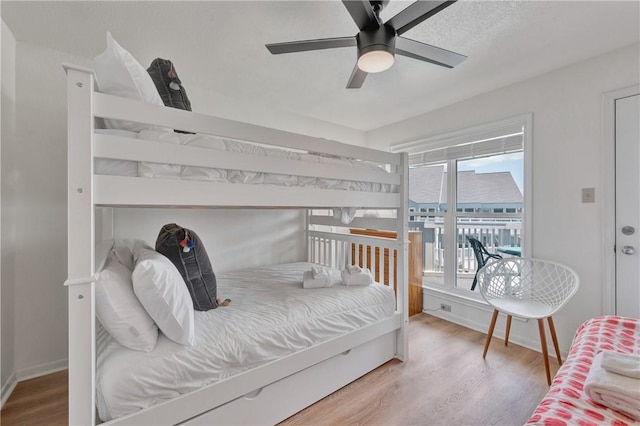 bedroom featuring multiple windows, ceiling fan, and wood-type flooring