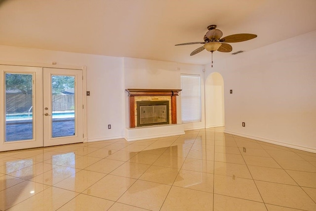 unfurnished living room featuring french doors, light tile patterned floors, and ceiling fan