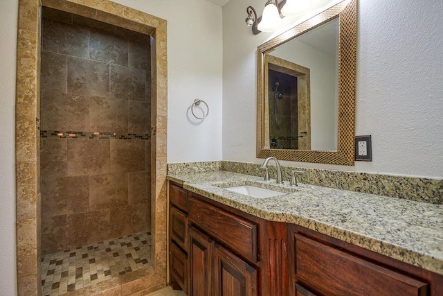 bathroom featuring vanity and tiled shower