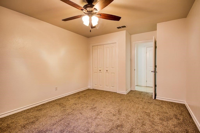 unfurnished bedroom with carpet, ceiling fan, and a closet