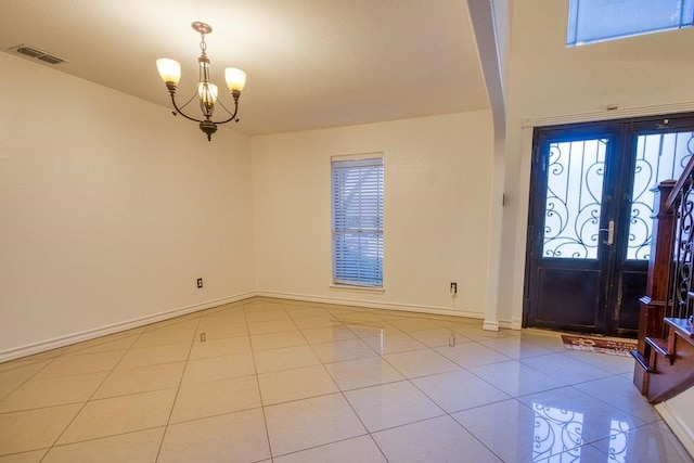 foyer entrance featuring an inviting chandelier, french doors, and light tile patterned flooring