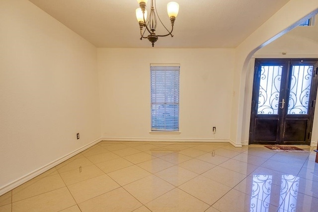 tiled foyer entrance featuring an inviting chandelier and french doors