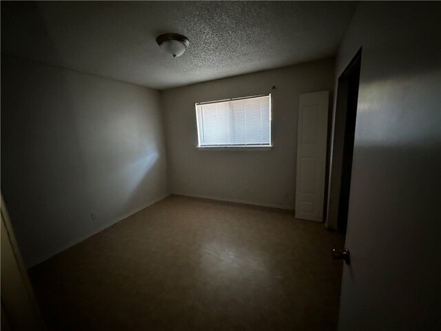 unfurnished room with a textured ceiling