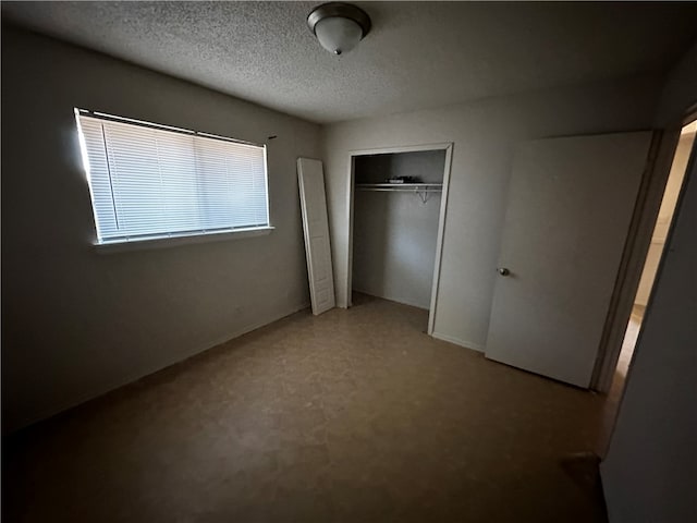 unfurnished bedroom featuring a textured ceiling and a closet