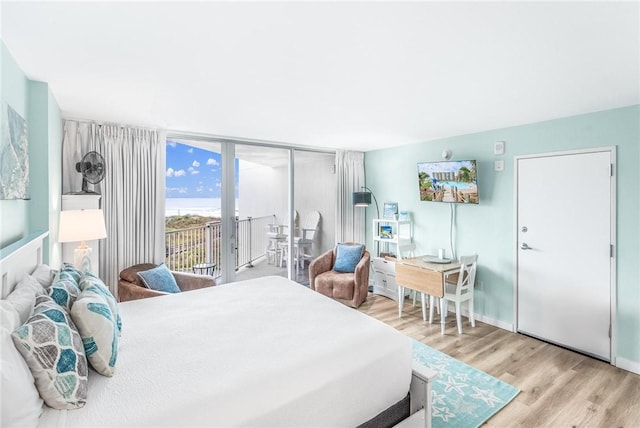 bedroom with access to outside and light hardwood / wood-style floors