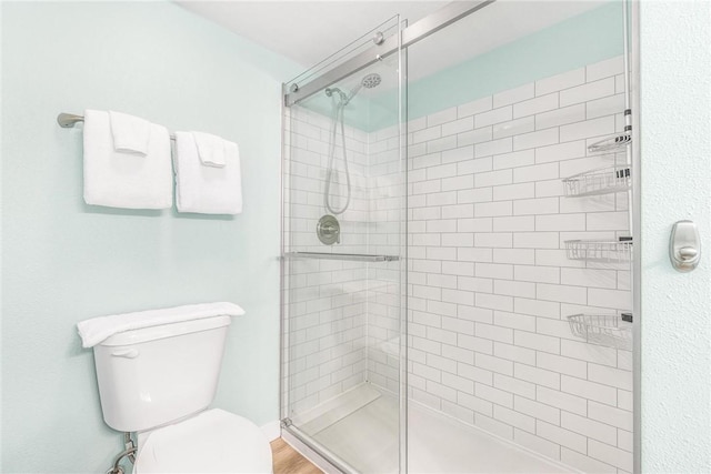 bathroom with hardwood / wood-style flooring, toilet, and walk in shower