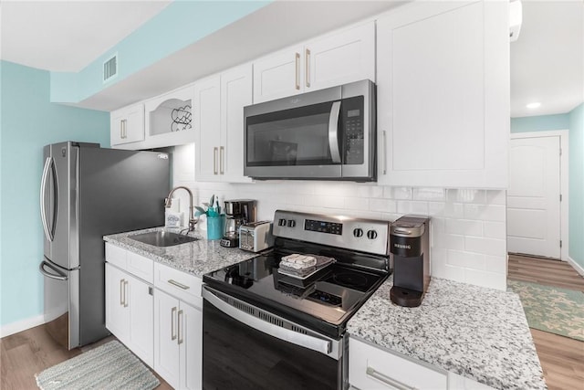 kitchen with light hardwood / wood-style flooring, stainless steel appliances, white cabinetry, and sink