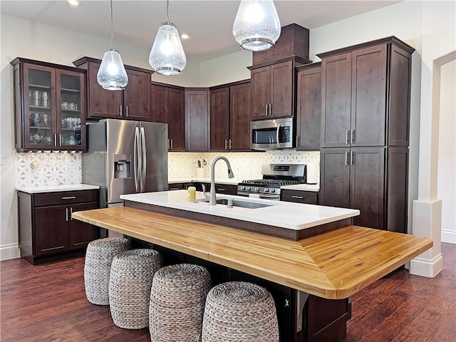 kitchen featuring a sink, stainless steel appliances, tasteful backsplash, and light countertops