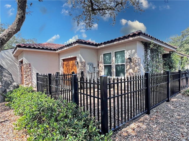 exterior space featuring a tiled roof, fence, and stucco siding