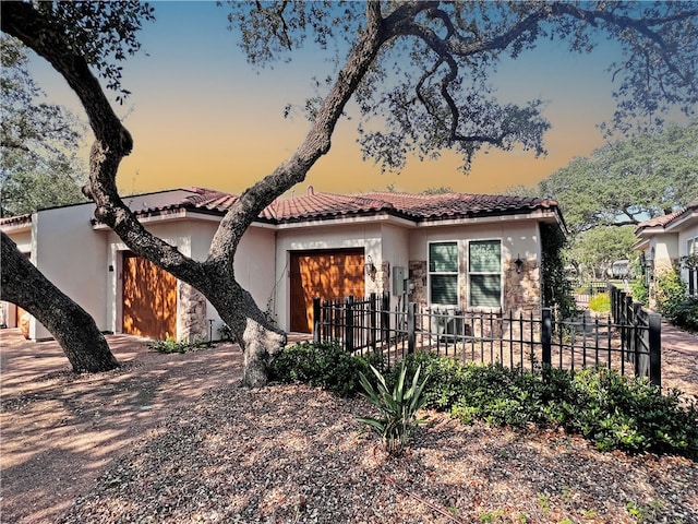 view of front facade featuring fence, driveway, stucco siding, stone siding, and a tiled roof