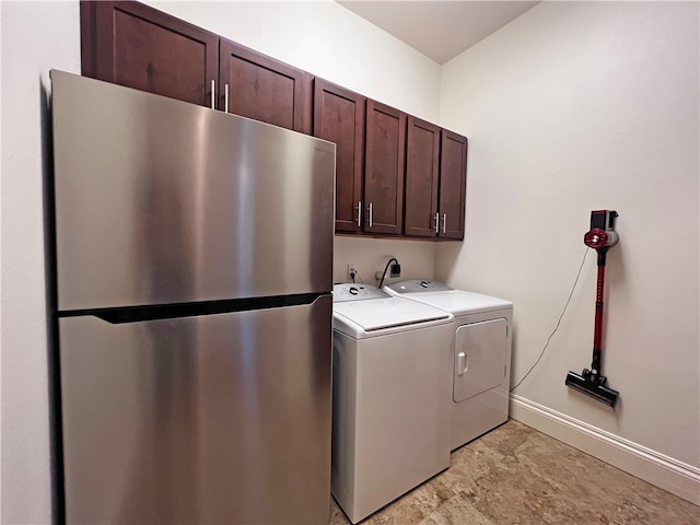 laundry room with washer and dryer, baseboards, and cabinet space