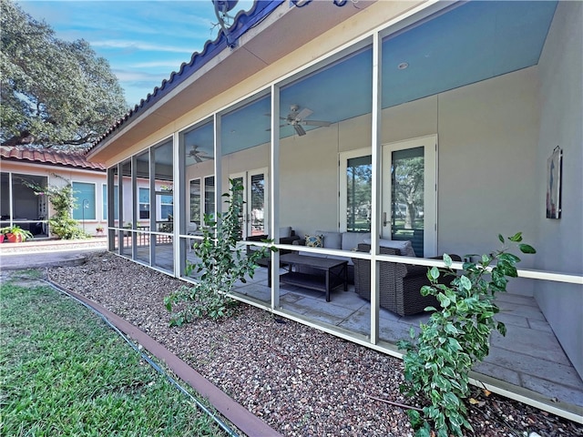 view of side of home featuring stucco siding, an outdoor hangout area, a patio area, and a sunroom