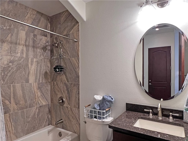 bathroom with vanity, bathing tub / shower combination, toilet, and a textured wall