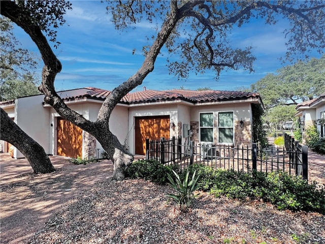 view of front of home with fence, a tiled roof, stucco siding, stone siding, and an attached garage