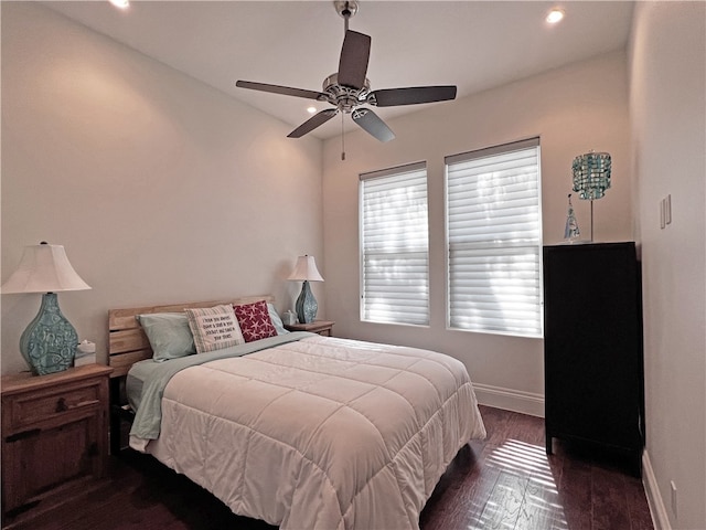 bedroom with dark wood-style floors, a ceiling fan, and baseboards