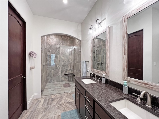 bathroom featuring double vanity, walk in shower, and a sink