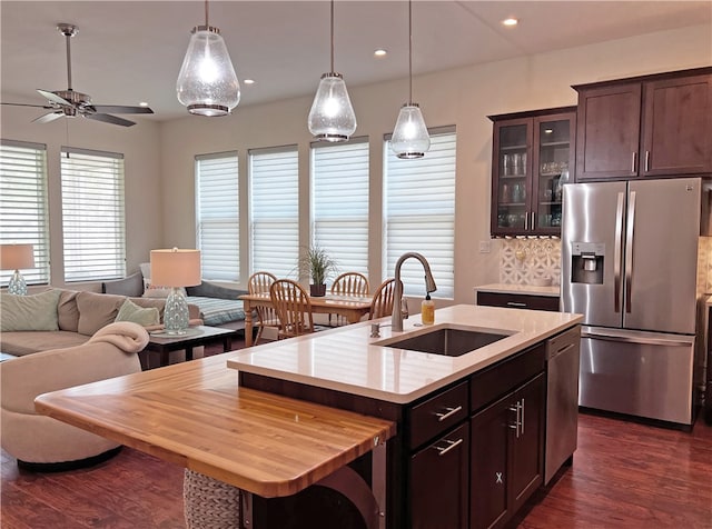 kitchen featuring dark wood-style floors, a sink, stainless steel appliances, dark brown cabinetry, and open floor plan