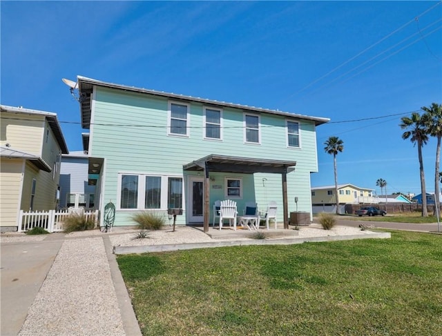 rear view of house with central AC, a patio, and a lawn