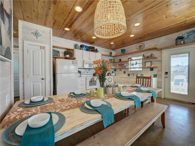 dining area with wooden walls, a chandelier, and wooden ceiling