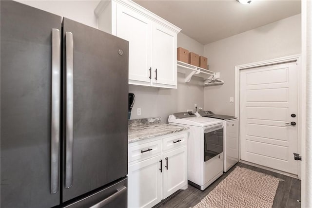 clothes washing area featuring wood finish floors, cabinet space, and washer and dryer