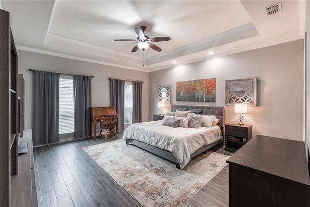 bedroom featuring dark wood-style floors, a tray ceiling, and visible vents