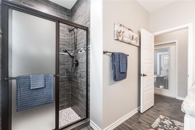 bathroom featuring a stall shower, wood finished floors, and baseboards