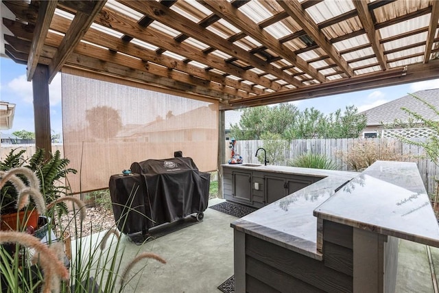 view of patio / terrace with a sink, a fenced backyard, a grill, and a pergola