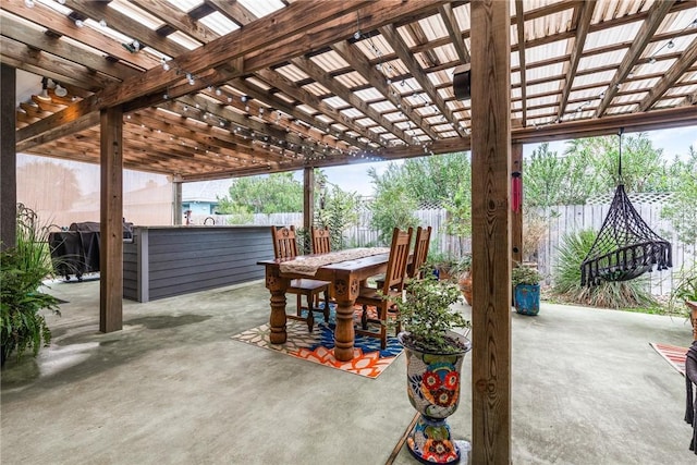 view of patio with outdoor dining space, fence, and a pergola