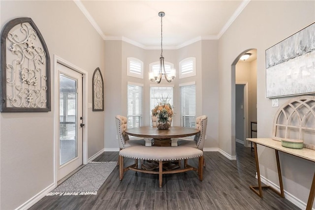 dining area with dark wood-style floors, baseboards, arched walkways, and crown molding