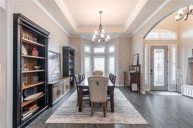 dining area featuring a tray ceiling, dark wood finished floors, baseboards, and an inviting chandelier