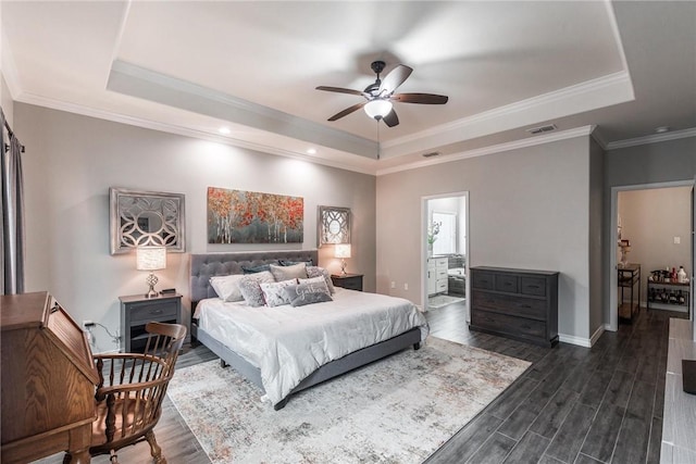 bedroom with a tray ceiling, dark wood-type flooring, and visible vents