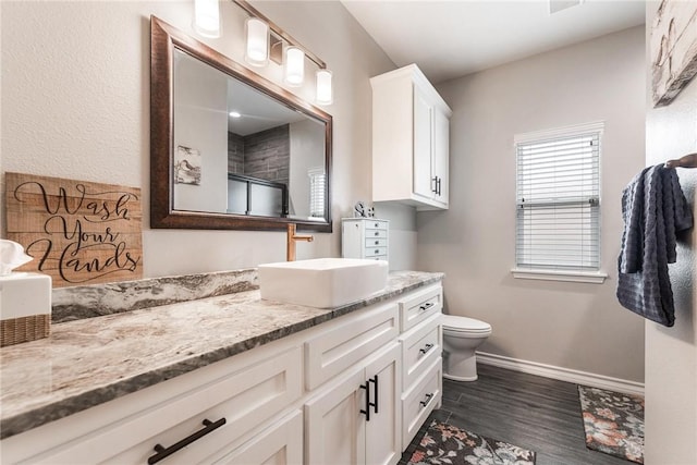 full bath with toilet, wood finished floors, vanity, baseboards, and an enclosed shower