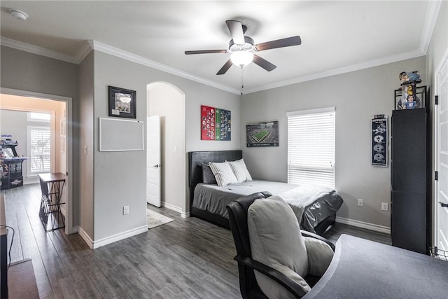 bedroom featuring baseboards, arched walkways, ceiling fan, ornamental molding, and dark wood-type flooring