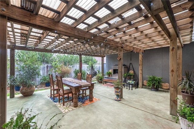 view of patio featuring outdoor dining area, fence, and a pergola