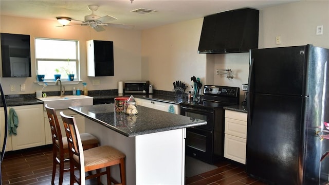 kitchen featuring a breakfast bar, a center island, dark wood-type flooring, black appliances, and sink