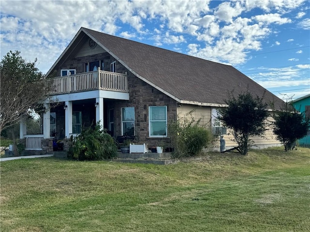 back of house featuring a lawn, a balcony, and covered porch