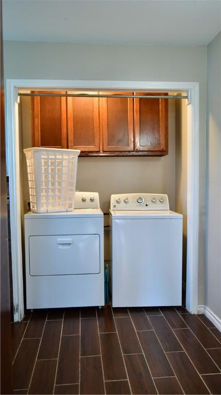 clothes washing area featuring washer and clothes dryer and cabinets