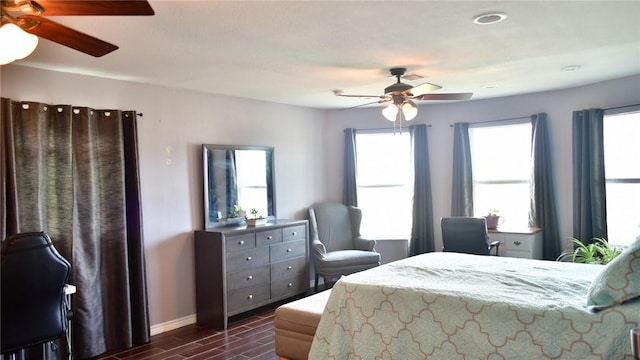 bedroom featuring multiple windows, dark wood-type flooring, and ceiling fan