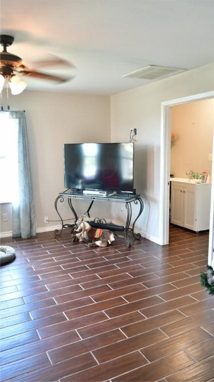 unfurnished living room featuring dark hardwood / wood-style floors, ceiling fan, and sink