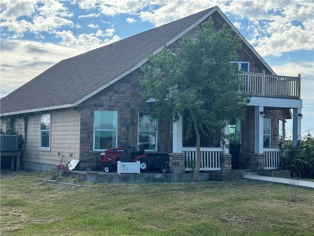 exterior space with a balcony, a front lawn, and covered porch