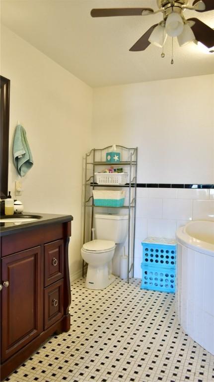 bathroom featuring tile patterned floors, vanity, ceiling fan, and toilet