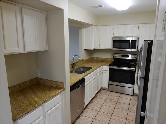 kitchen with white cabinetry, sink, light stone countertops, and stainless steel appliances