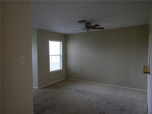 empty room featuring ceiling fan and light carpet