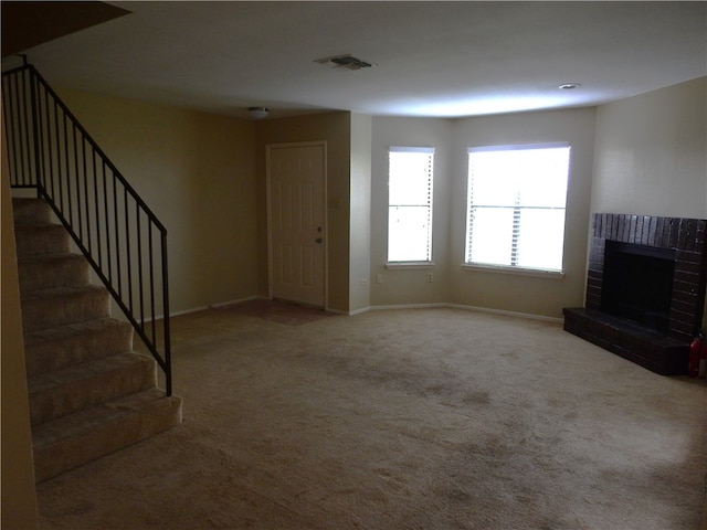 unfurnished living room featuring a brick fireplace and carpet floors