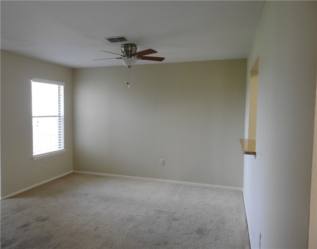 carpeted spare room featuring ceiling fan