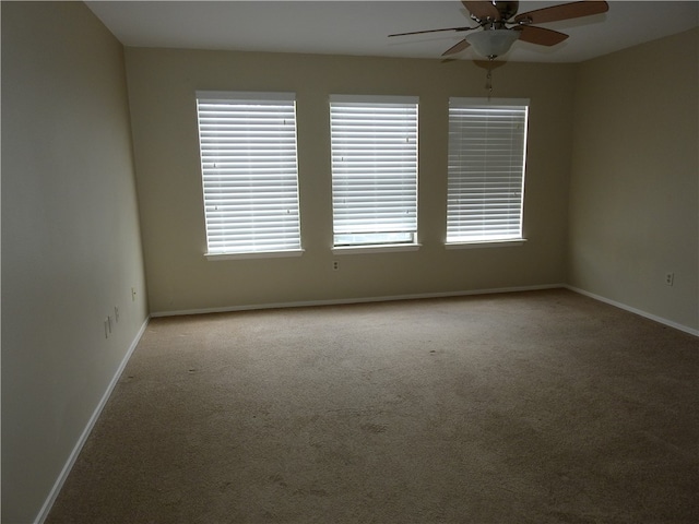 carpeted spare room featuring ceiling fan