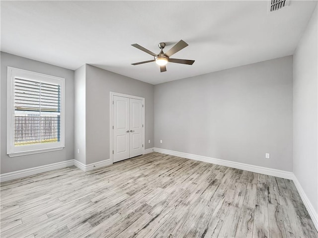 unfurnished room featuring visible vents, baseboards, and wood finished floors