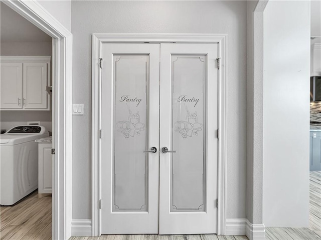 interior space with washer / clothes dryer, wood finished floors, and baseboards