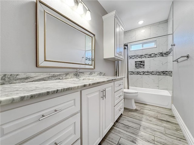 bathroom featuring baseboards, toilet, shower / washtub combination, and vanity