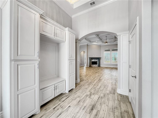 mudroom featuring light wood-type flooring, visible vents, coffered ceiling, arched walkways, and ceiling fan